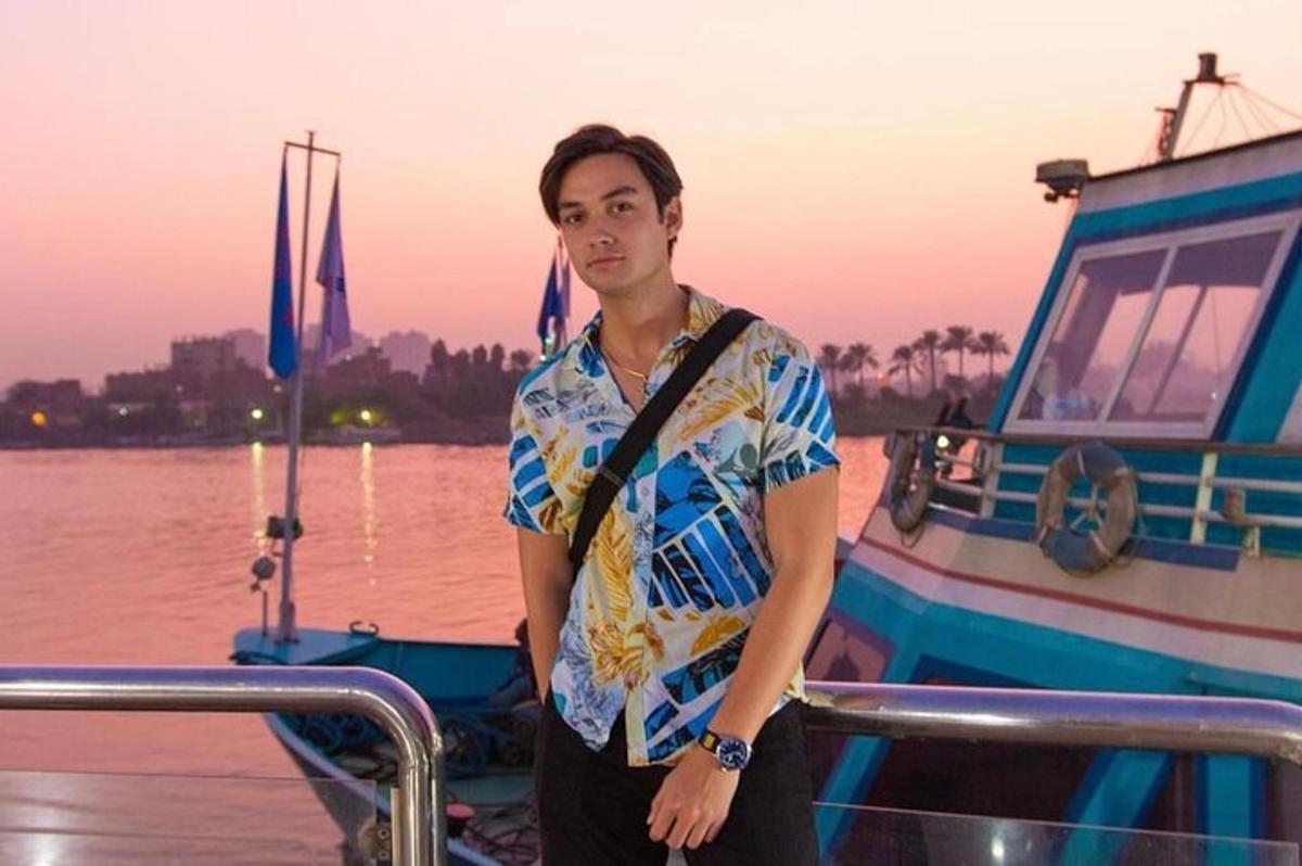 a man standing on a boat in front of the water