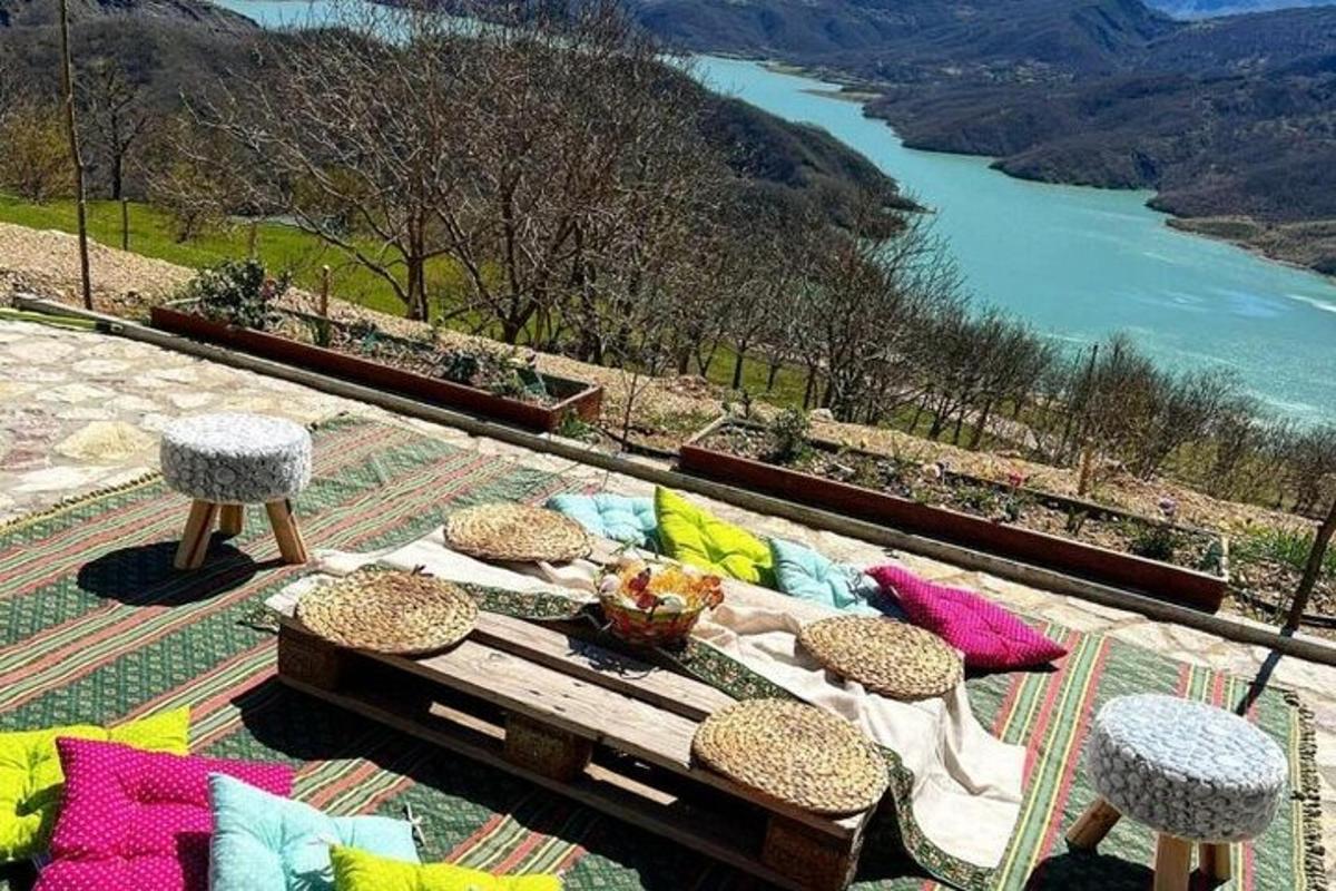 a patio with a table and chairs and a view of a river