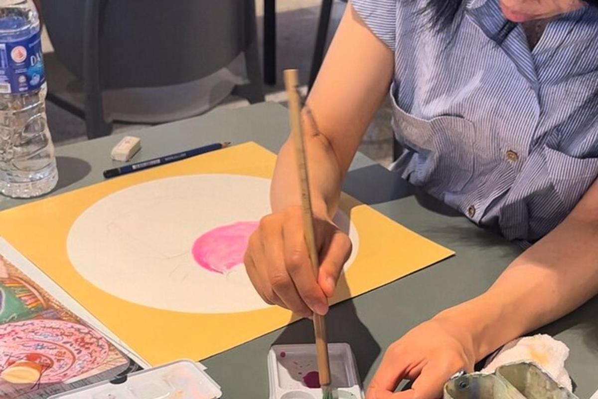seorang wanita sedang melukis gambar dengan berus
