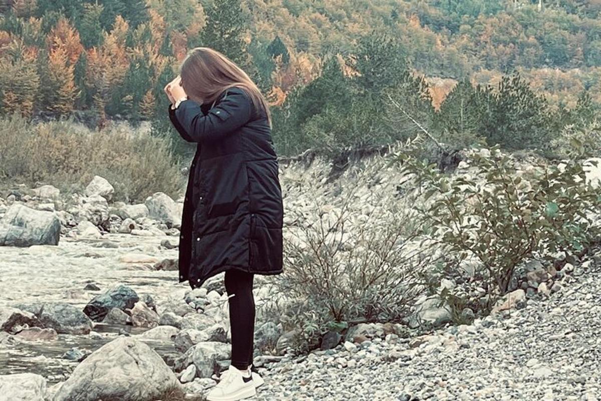 una donna in piedi sulle rocce vicino a un fiume
