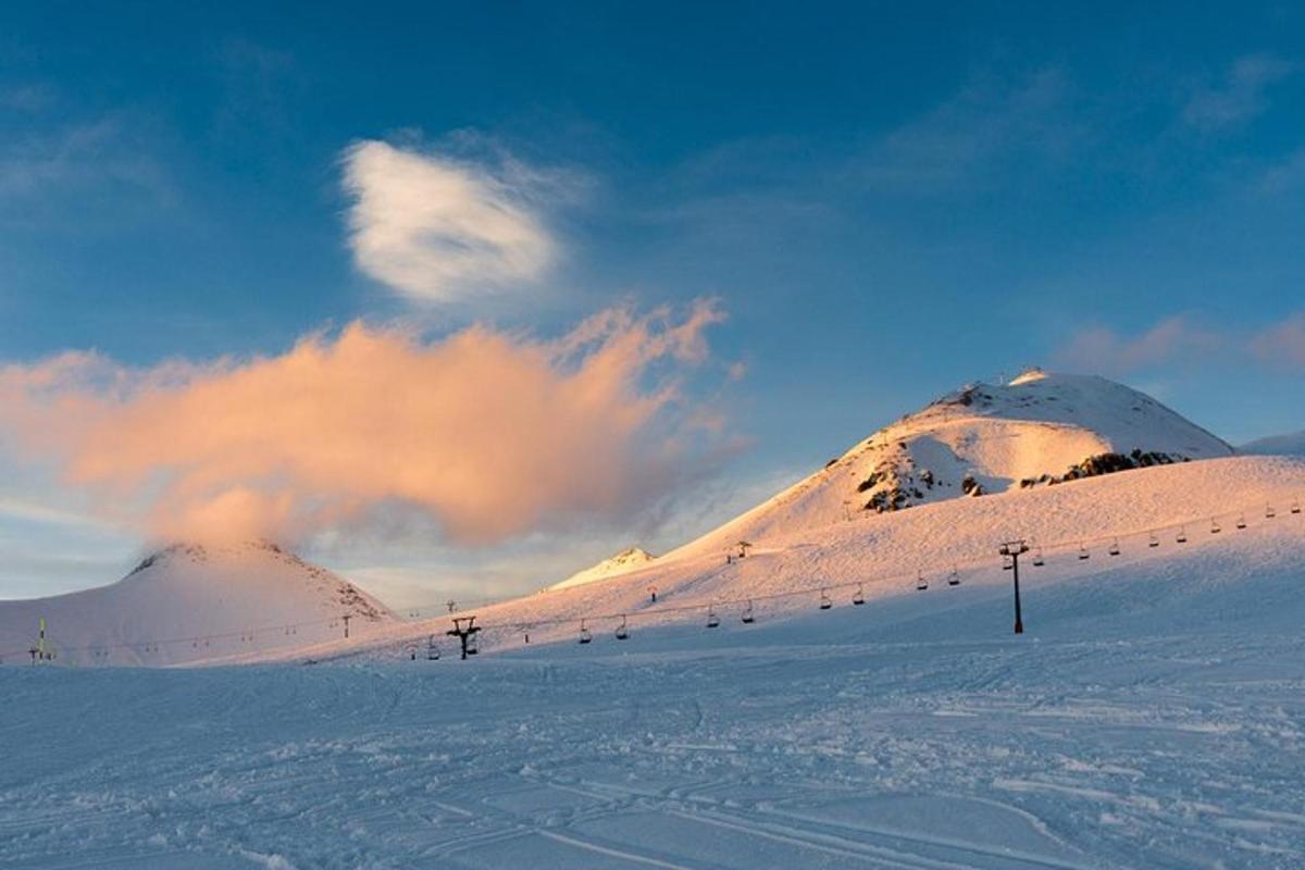 uma montanha coberta de neve com um teleférico