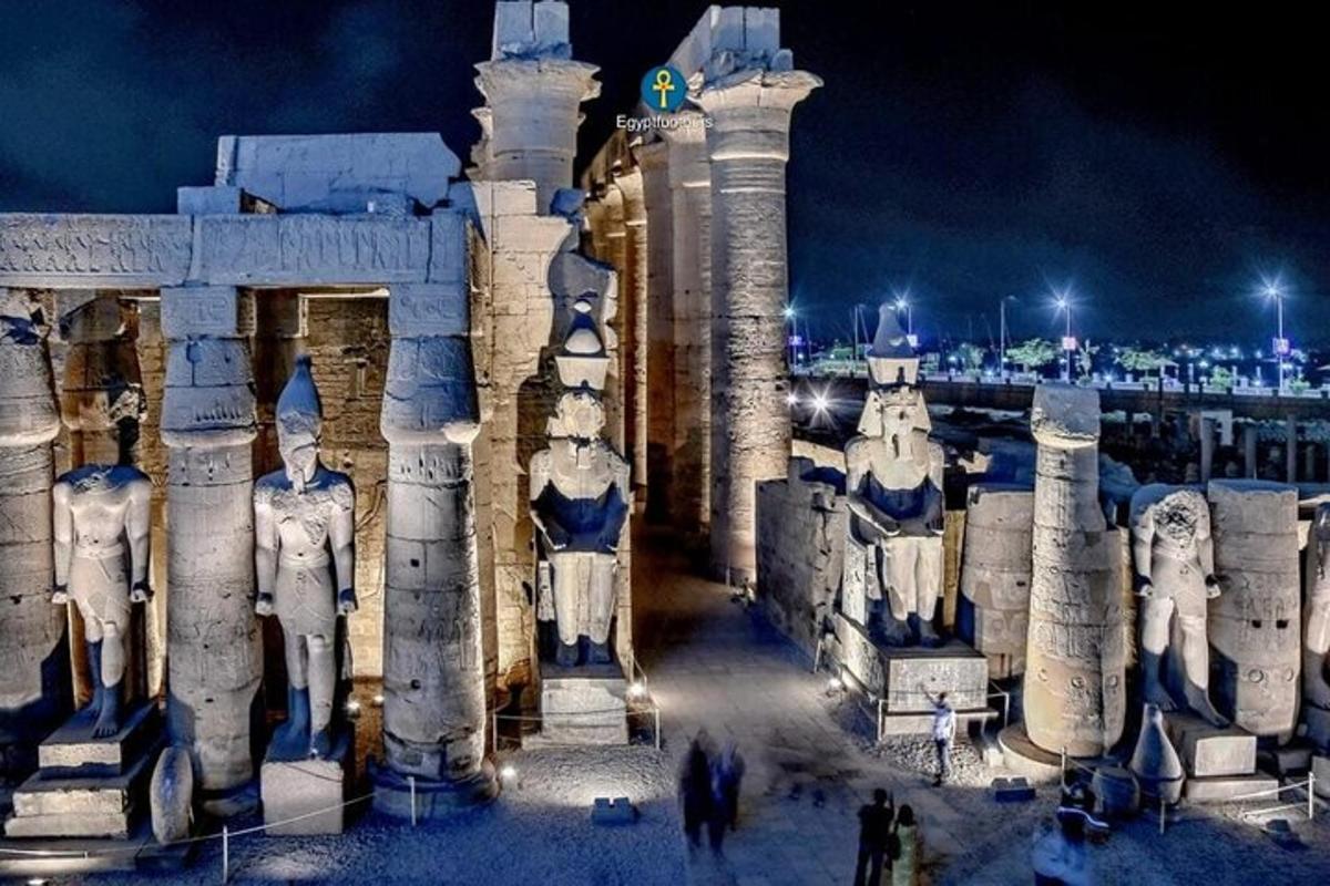 ένα κτίριο με αγάλματα ανθρώπων μπροστά του τη νύχτα