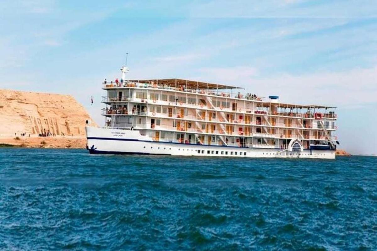 a large cruise ship on the water near a cliff