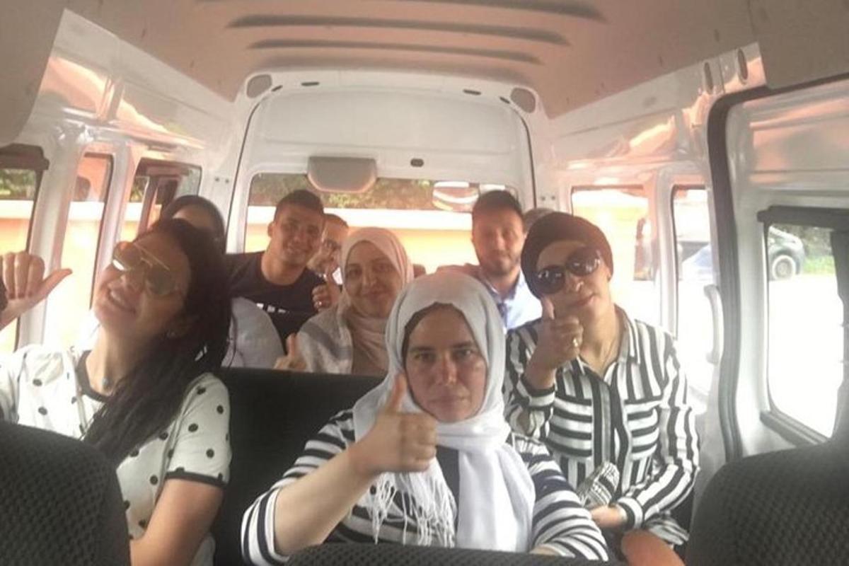 egy csoport ember ül egy buszon, felmutatva a hüvelykujját
