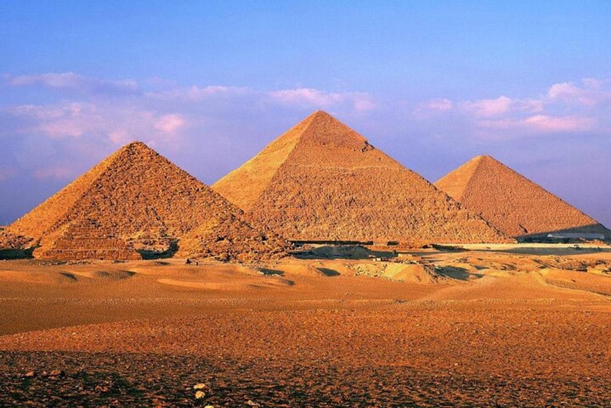 un gruppo di piramidi nel deserto sotto un cielo azzurro
