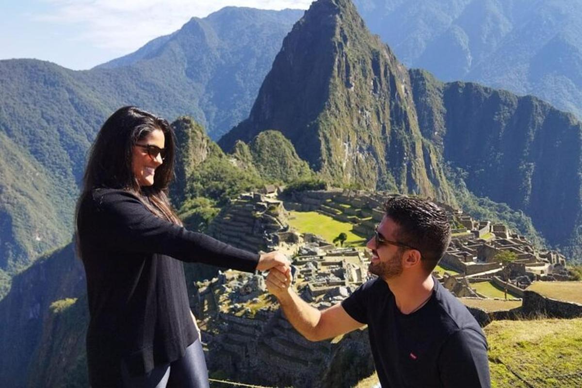 un uomo e una donna che si stringono la mano in cima a una montagna