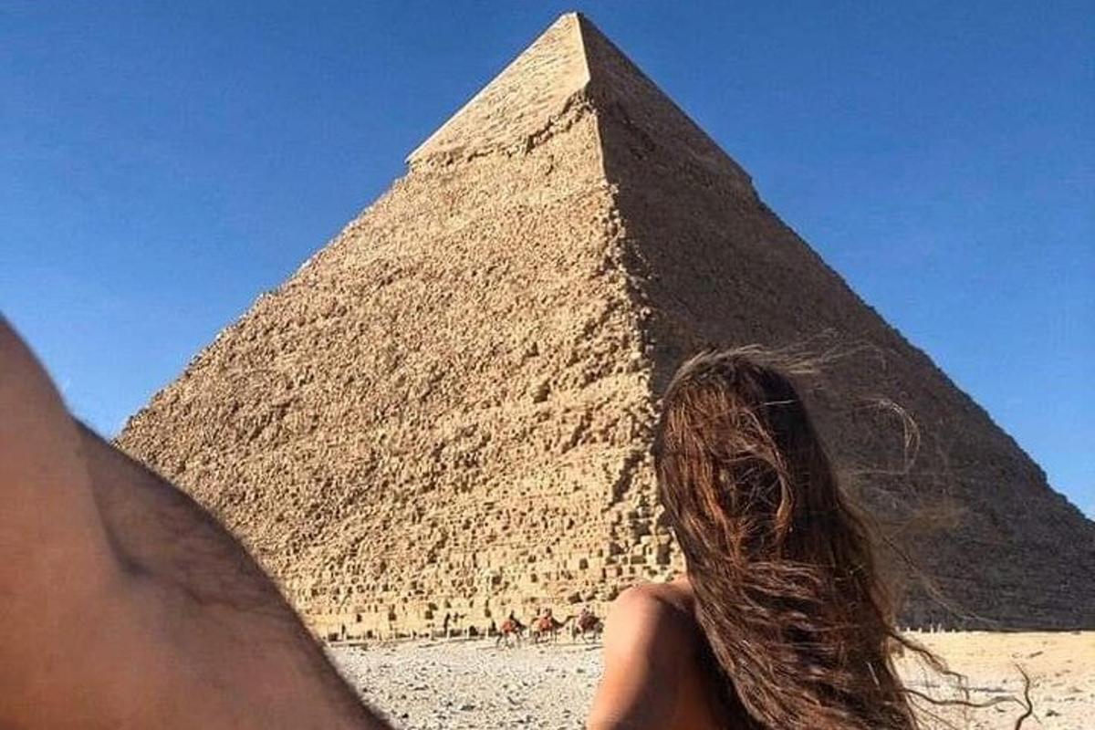 uma pessoa em pé em frente a uma pirâmide