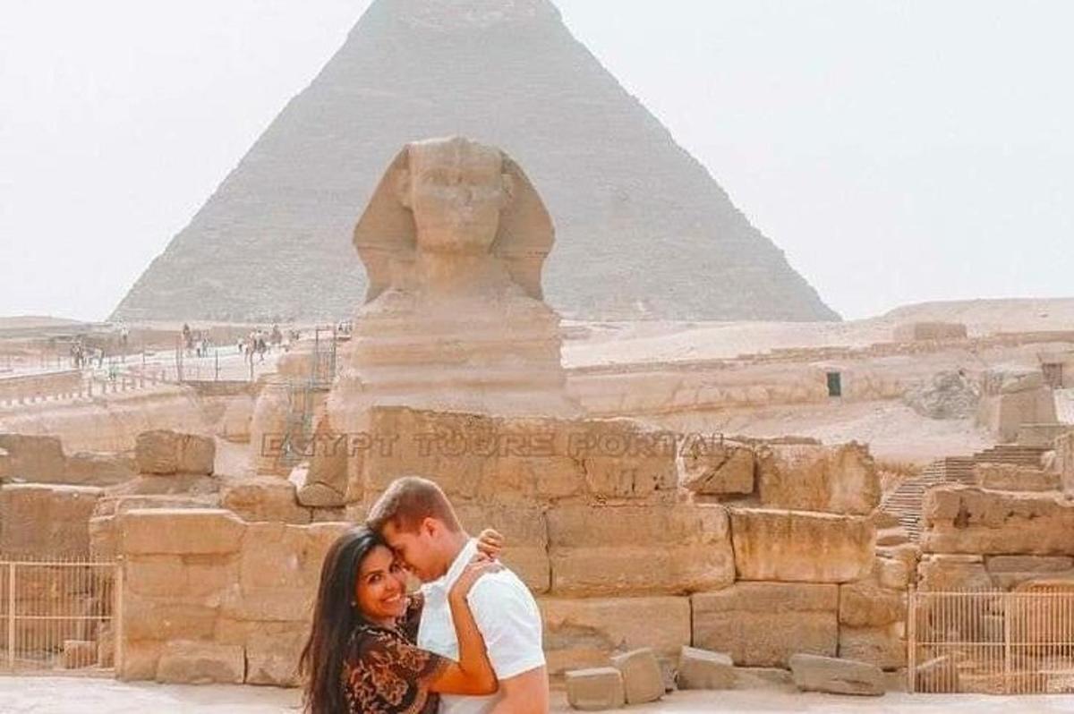 un uomo e una donna in posa davanti alla piramide