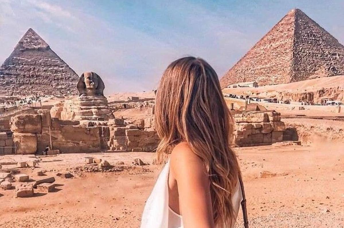 uma mulher em pé em frente às pirâmides