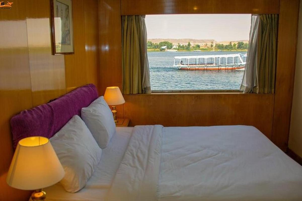una camera da letto con un letto e una finestra con una barca in acqua
