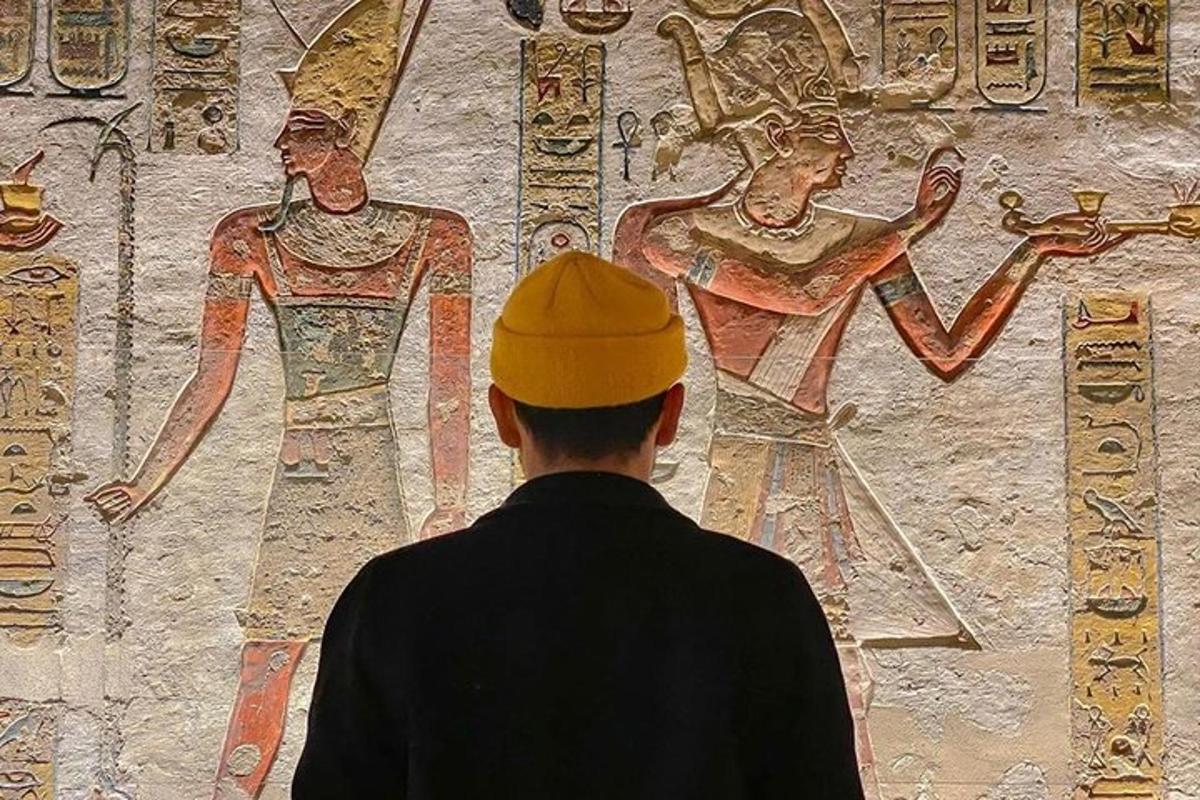 un uomo in piedi davanti a un muro con un dipinto
