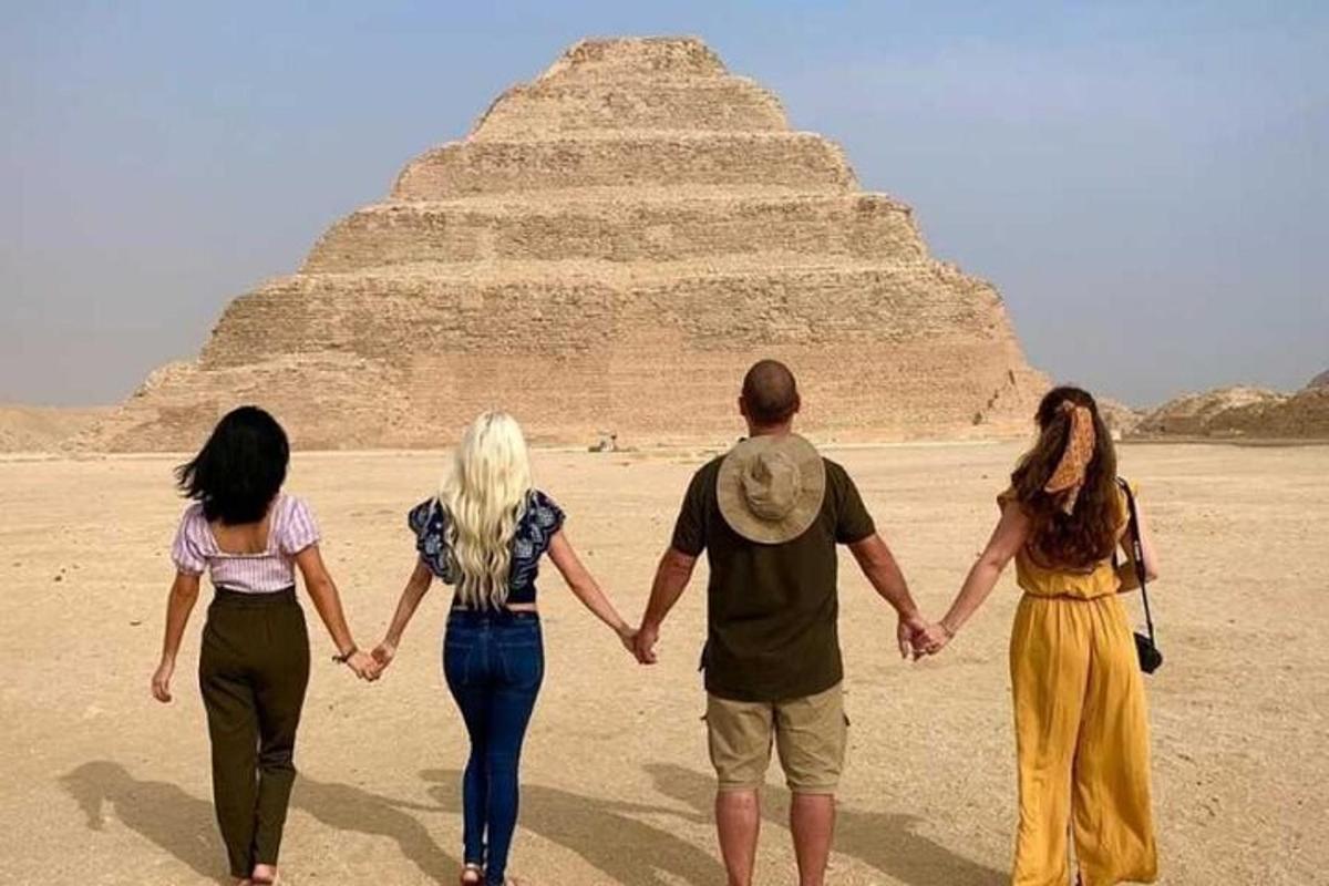 ihmisryhmä kävelee pyramidin edessä