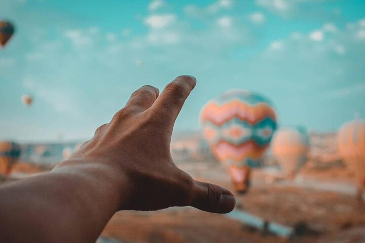 a hand is pointing at a spider man balloon