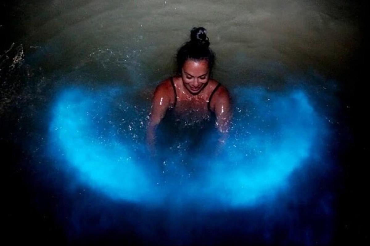 una donna in una piscina d'acqua con luci blu