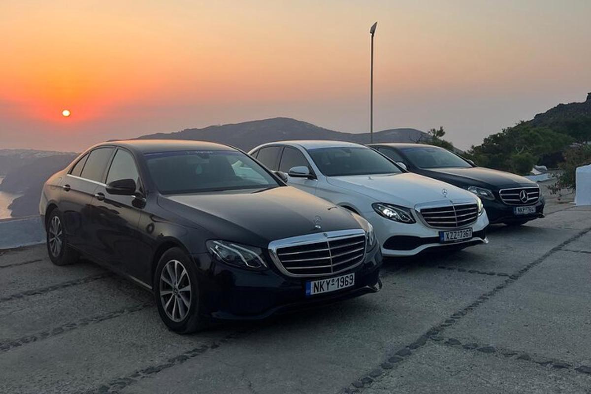 trije avtomobili parkirani na parkirišču s sončnim zahodom v ozadju