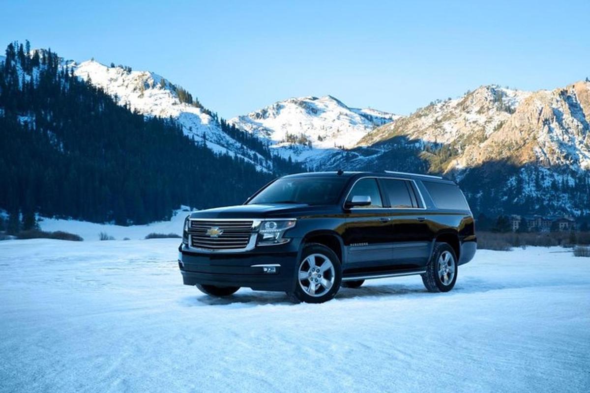 o camionetă neagră parcată în zăpadă în munți