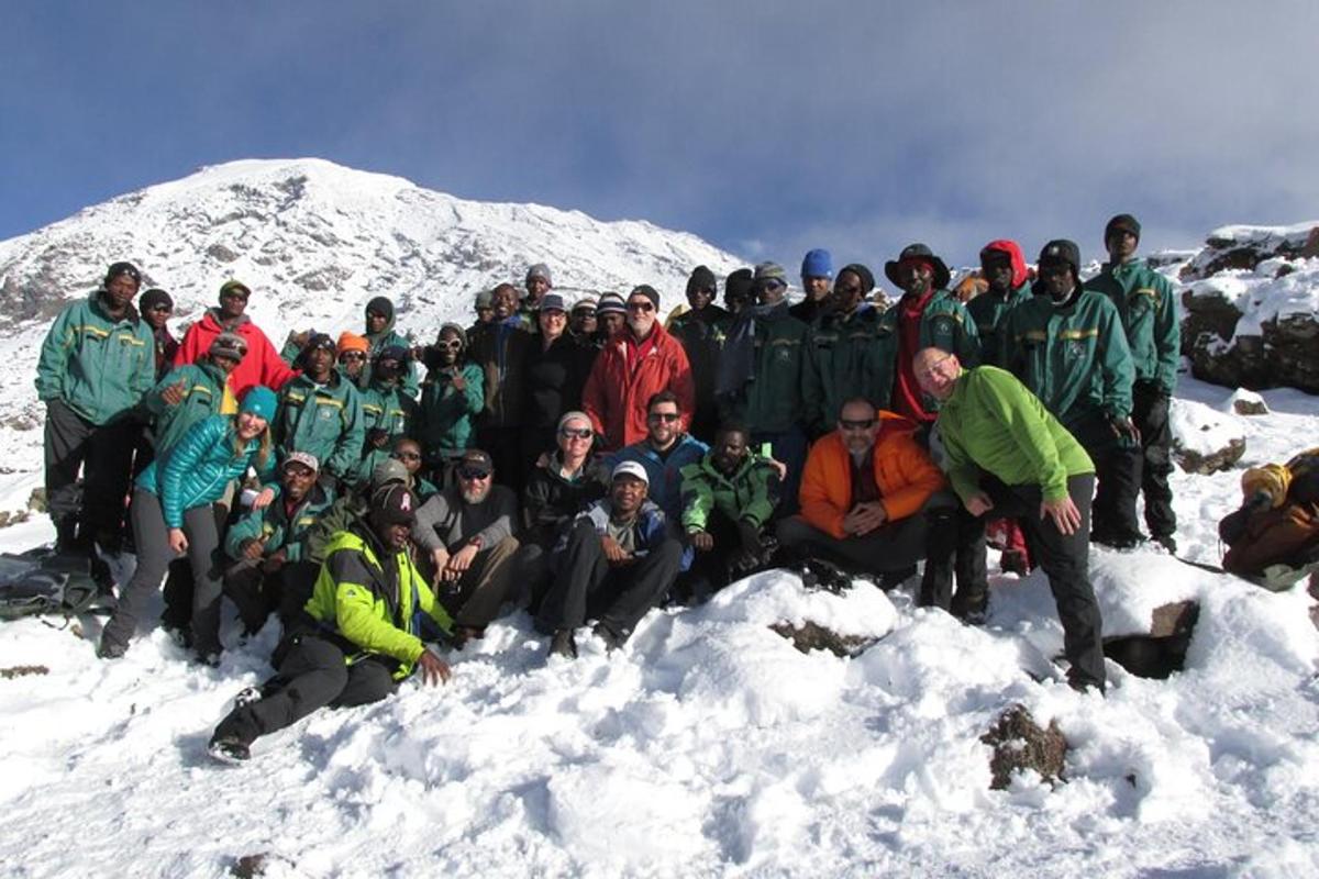 en gruppe mennesker poserer for et bilde i snøen