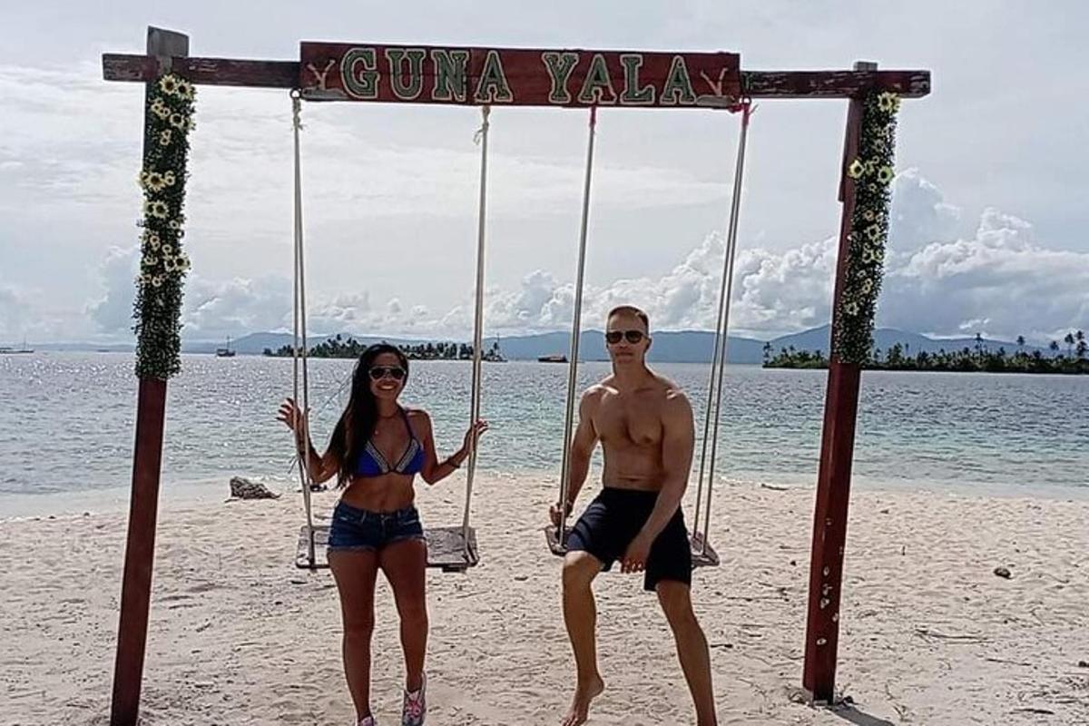 en man och en kvinna som sitter på en gunga på stranden