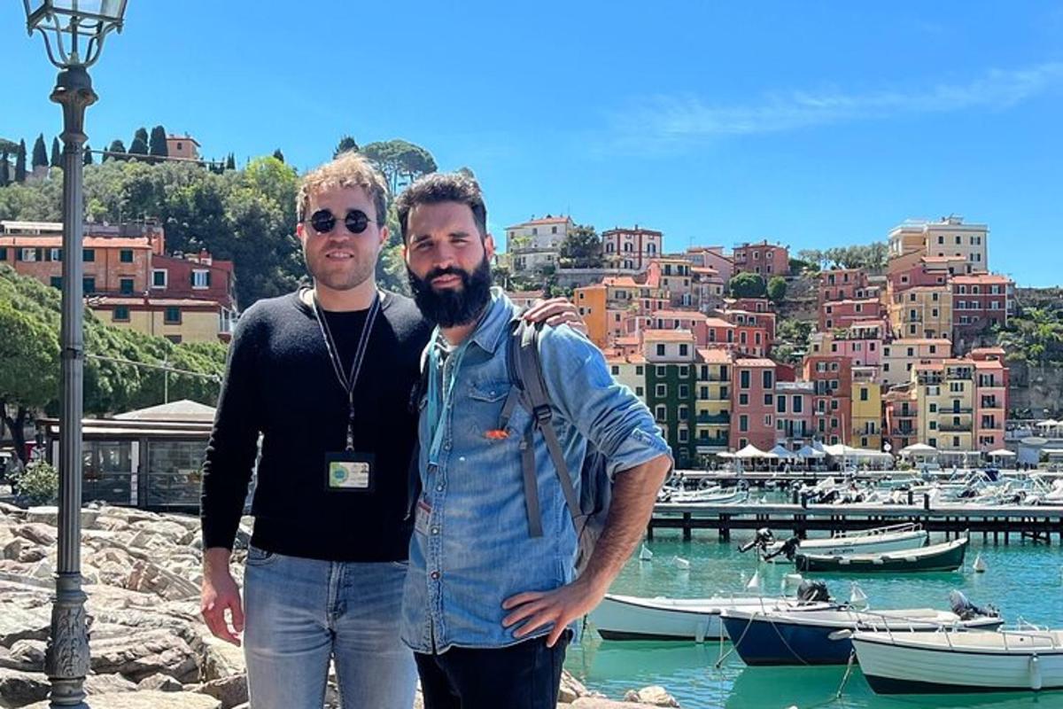 due uomini in piedi davanti a un porto con barche