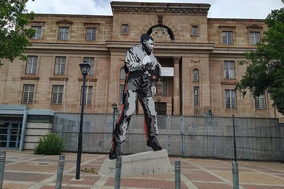 eine Statue eines Mannes, der vor einem Gebäude steht