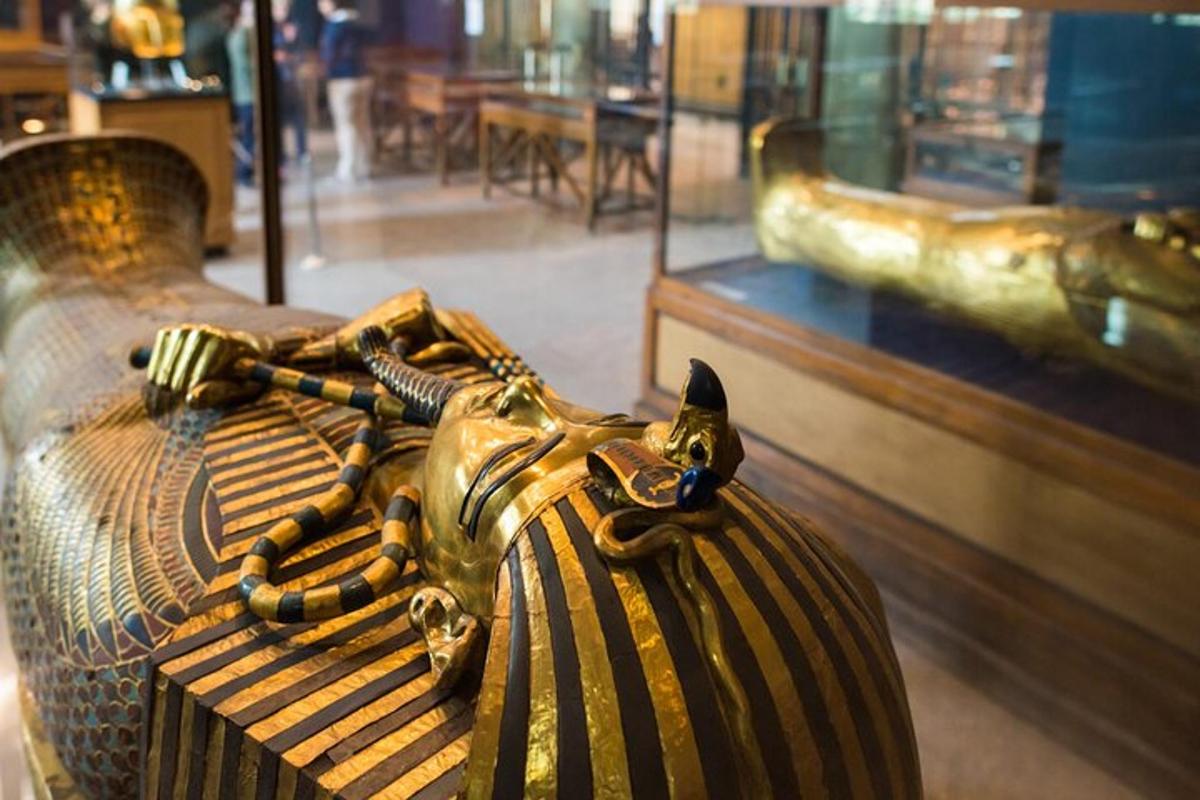 Una estatua de un gato acostado en un banco en un museo.
