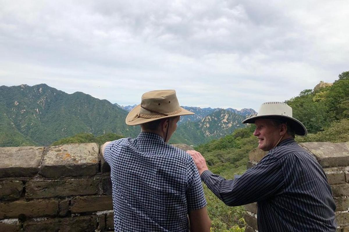 two men in hats standing on a wall