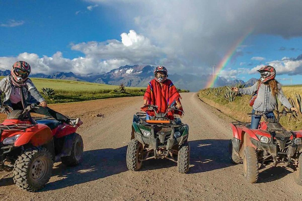 虹のかかった未舗装道路をATVに乗った3人