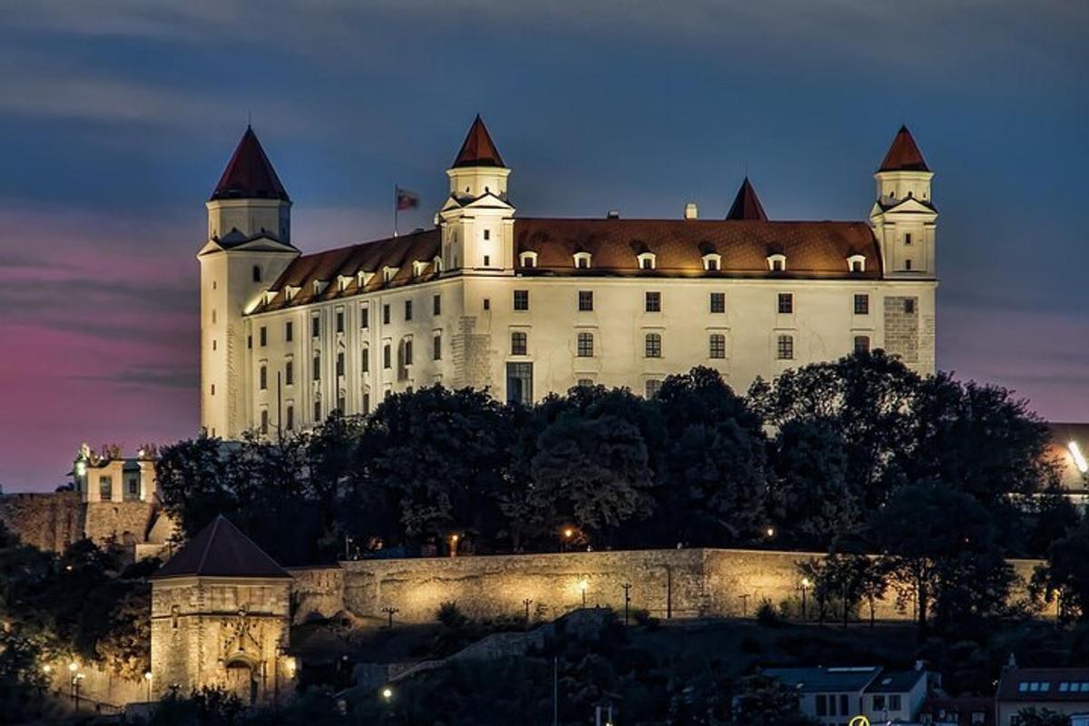 um castelo situado no topo de uma colina à noite