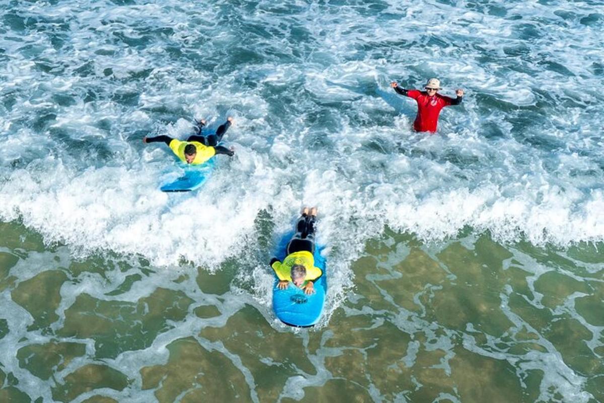 three people in the ocean on surfboards in the water