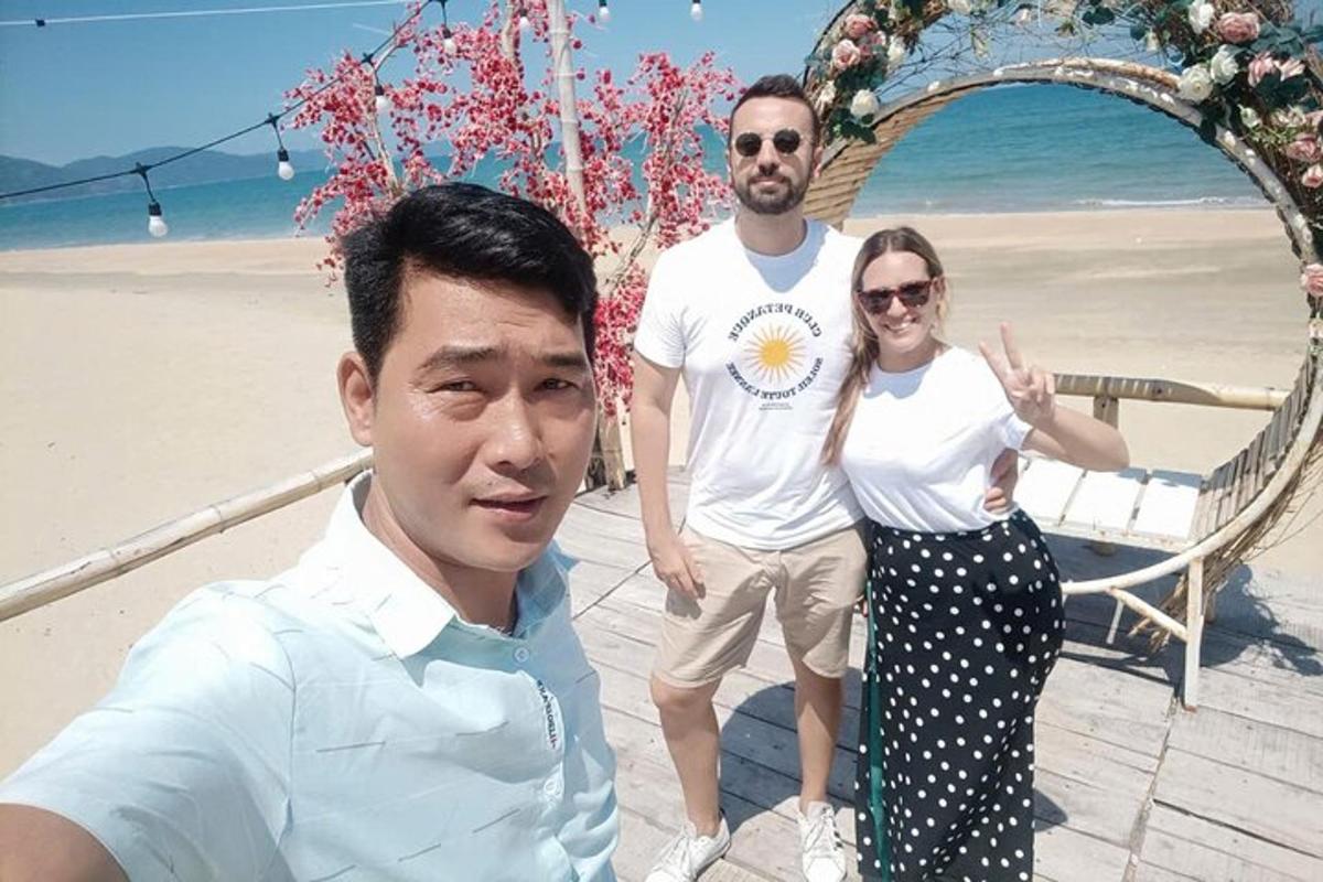 dva moška in ženska, ki stojijo na plaži