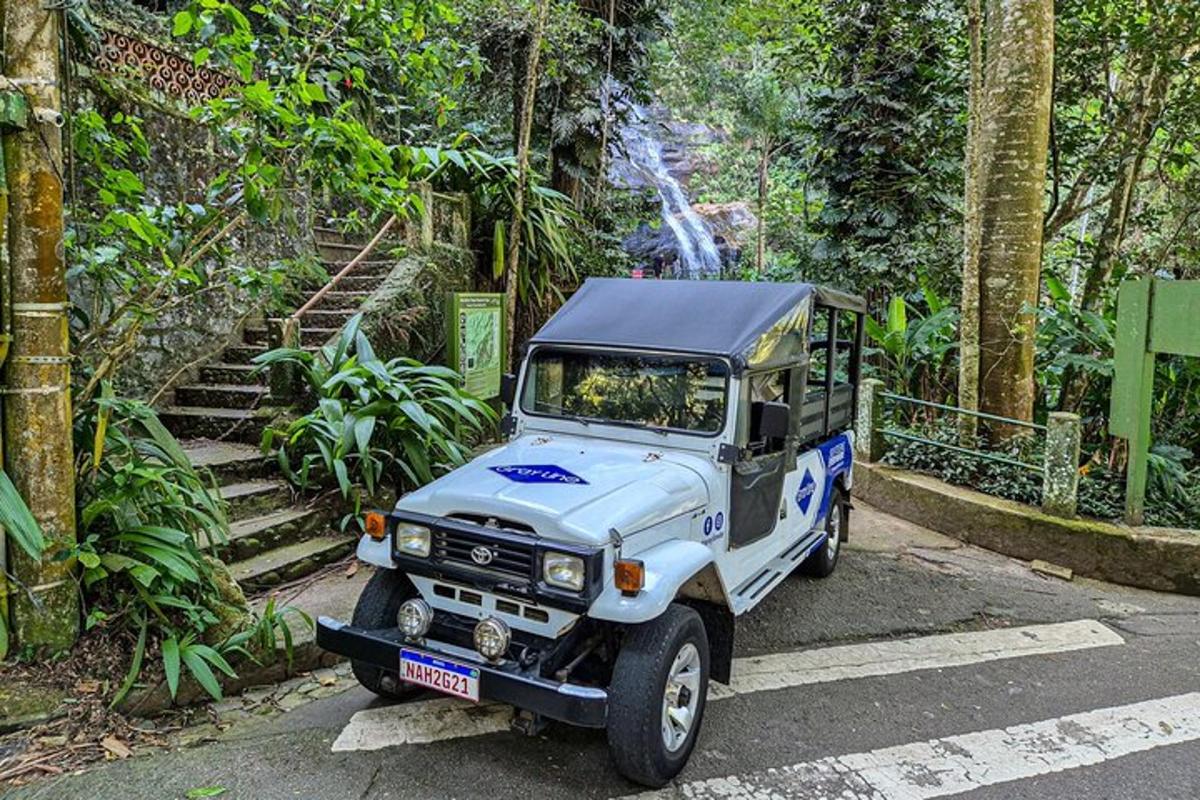 una jeep blu che percorre una strada in una foresta