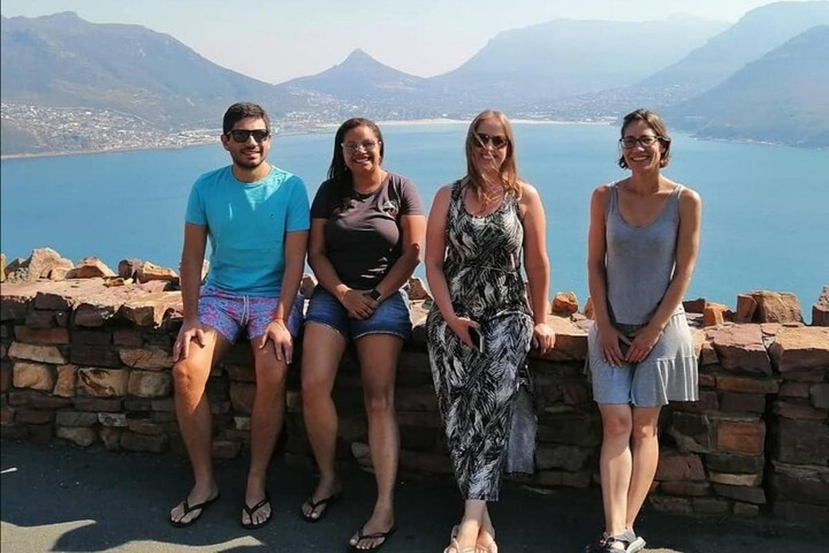 eine Gruppe von Menschen, die auf einer Mauer in der Nähe des Wassers sitzen