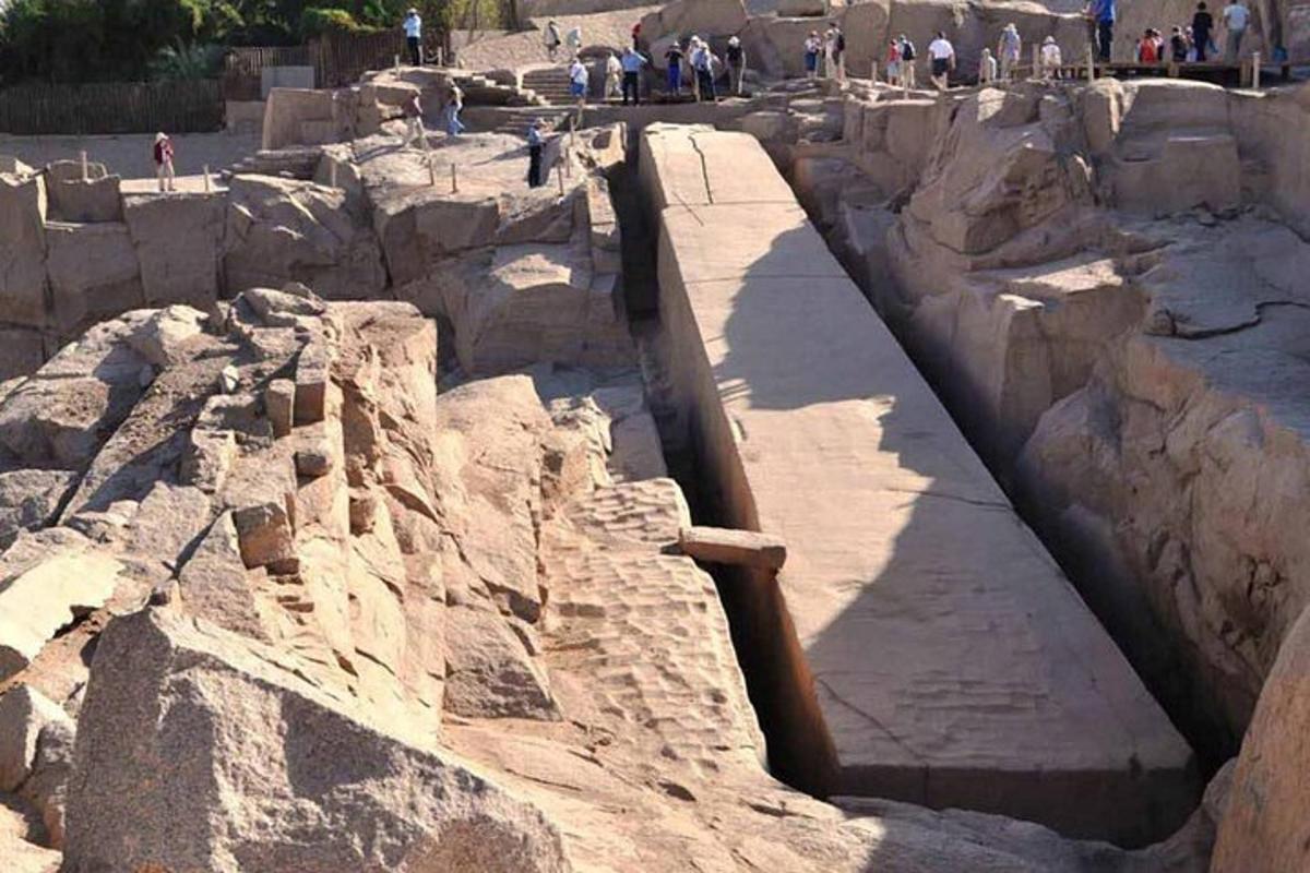 un gruppo di persone che camminano intorno a una grande struttura rocciosa