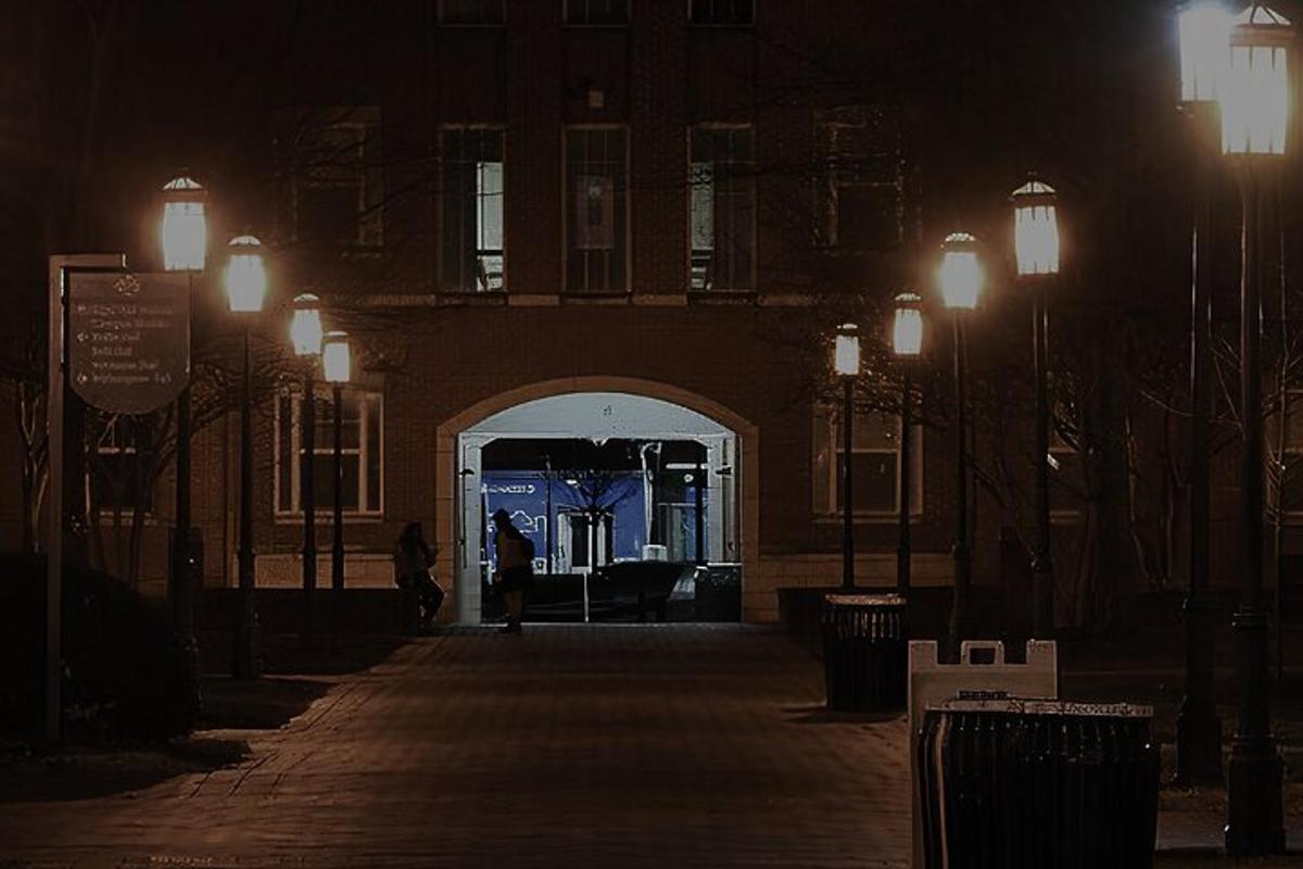 a person walking through an arch way at night