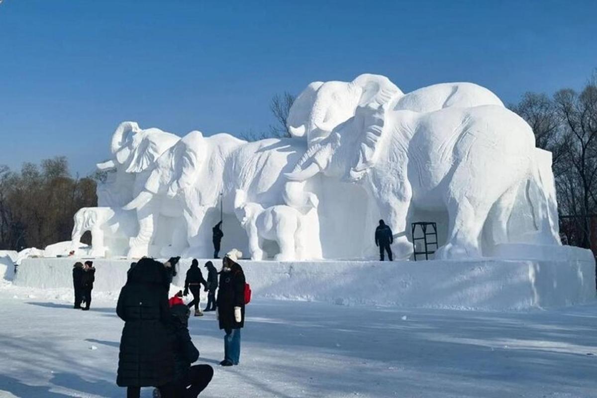 un gruppo di persone in piedi davanti a una scultura di ghiaccio