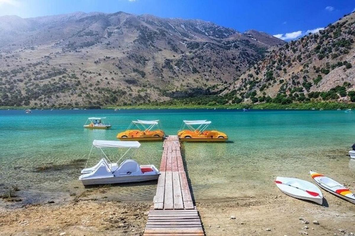 un doc cu bărci pe un lac cu munți