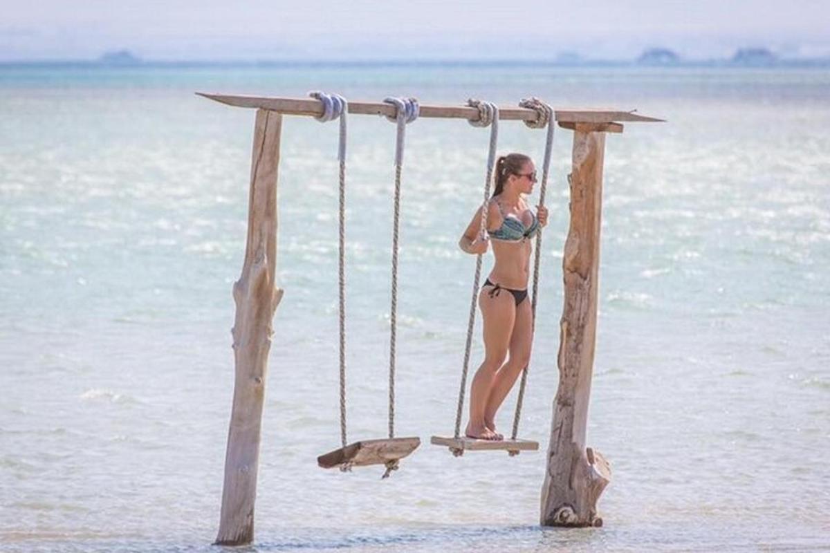 žena v bikinách na houpačce na pláži