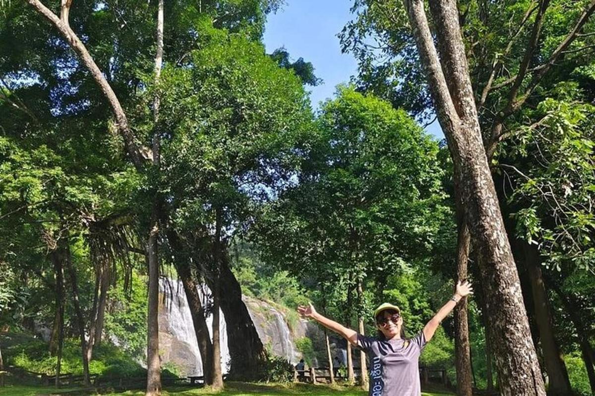 a young boy standing next to a tree with his arms out
