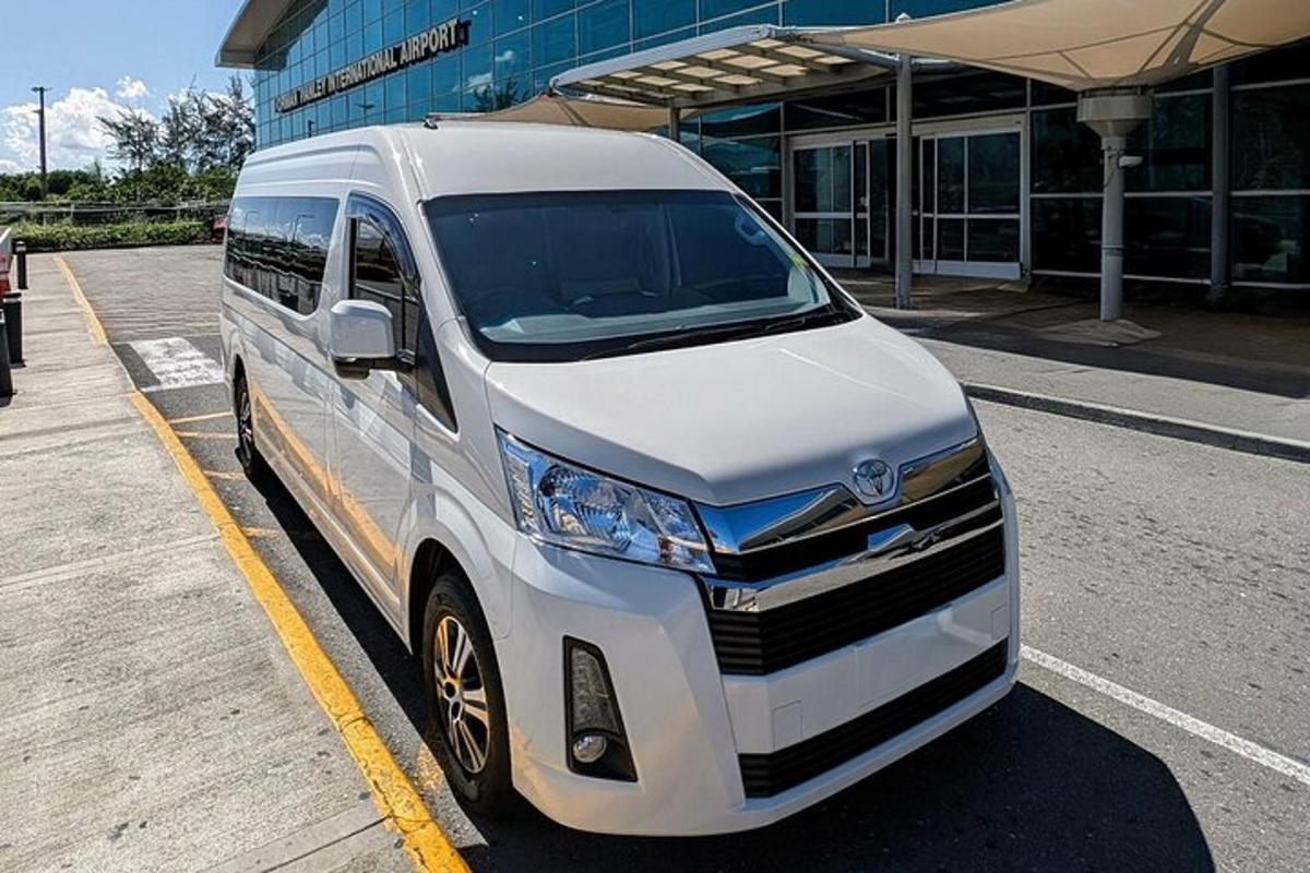 uma van branca estacionada em frente a um prédio
