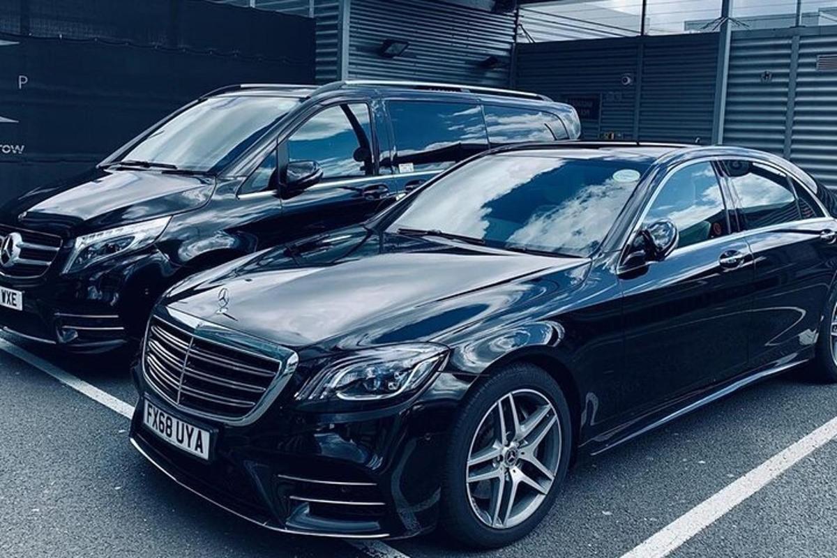 du automobiliai, pastatyti vienas šalia kito automobilių stovėjimo aikštelėje
