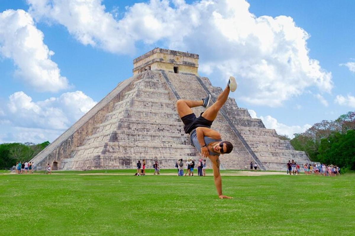 muž dělá stojku na rukou před pyramidou
