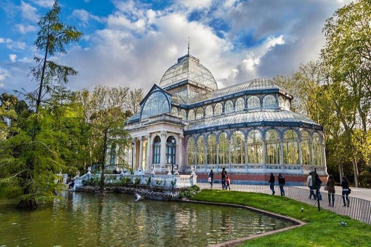un grande edificio di vetro con uno stagno di fronte