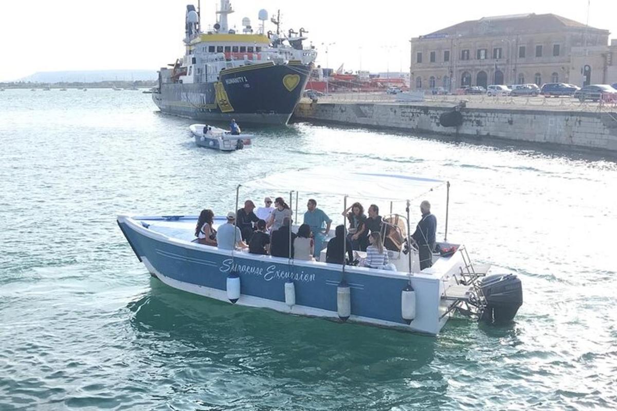 un grup de persones en un vaixell blau a l'aigua