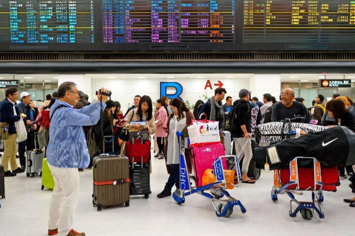 uma multidão de pessoas em um aeroporto com bagagem
