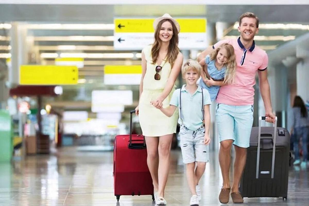 Μια οικογένεια περπατάει στο αεροδρόμιο με αποσκευές