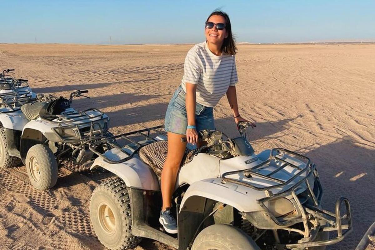una donna seduta su un quad nel deserto