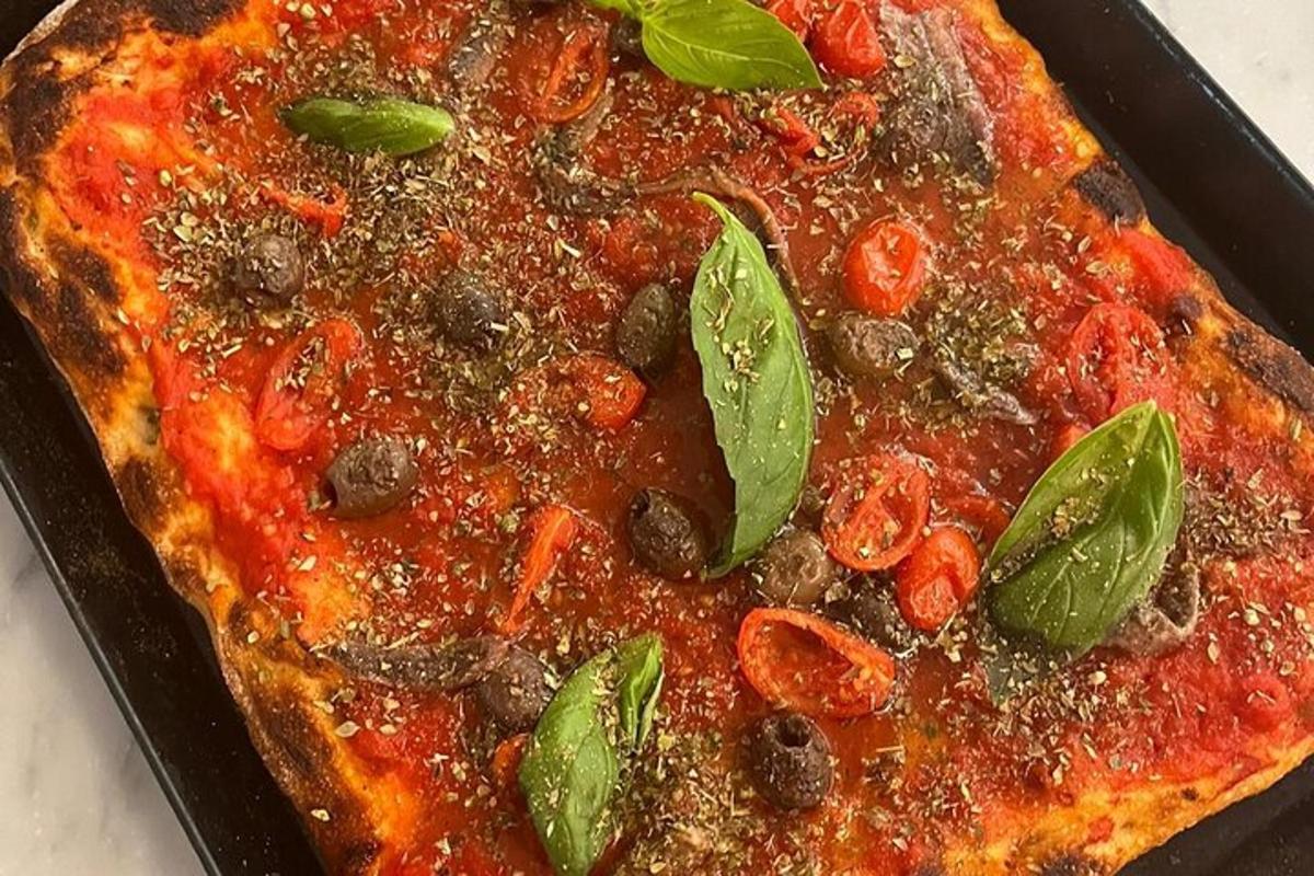 Una pizza en una sartén sobre una mesa