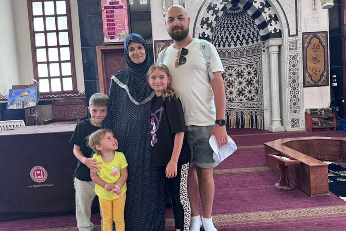 um homem, uma mulher e duas crianças em pé em uma mesquita
