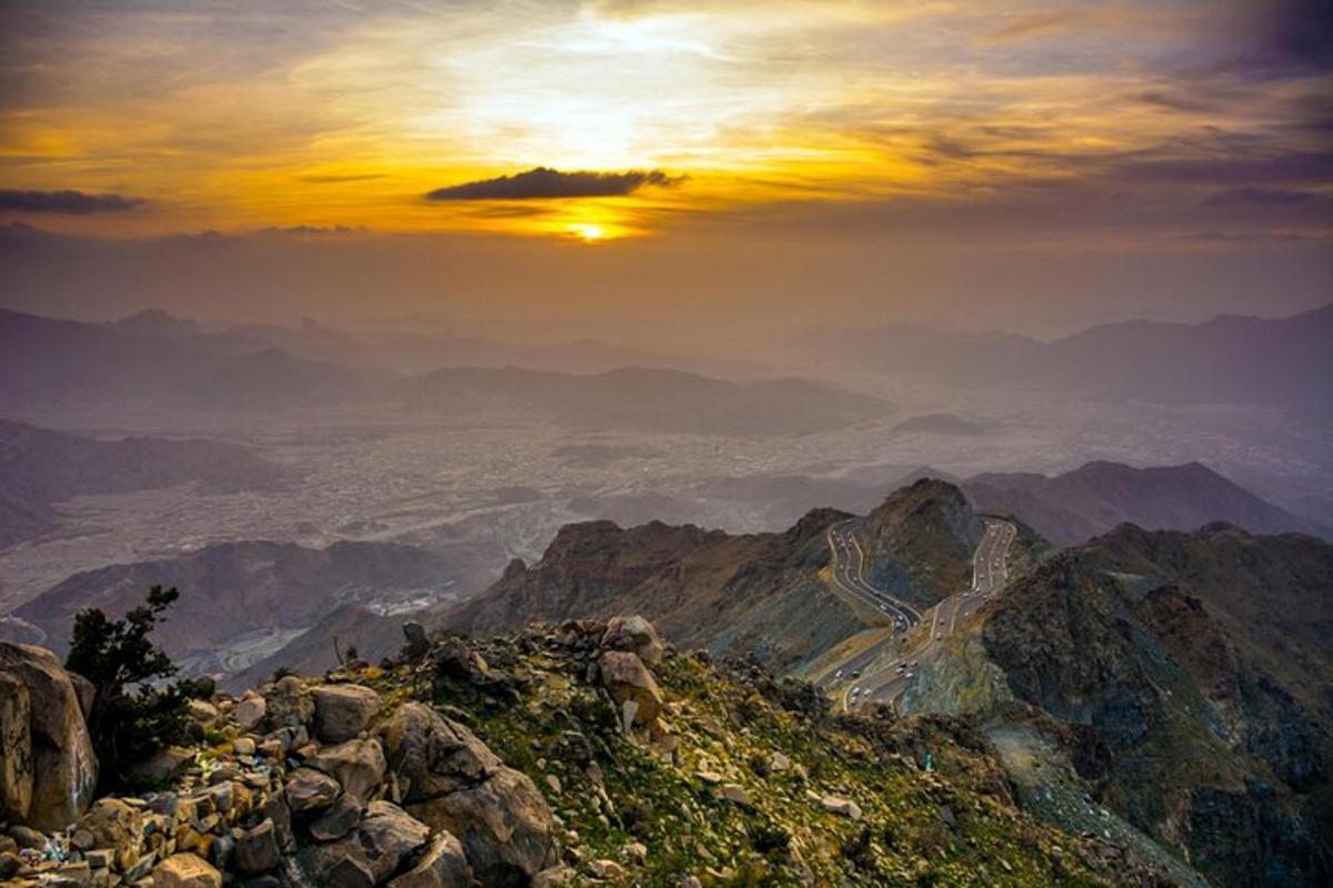 una vista di una montagna con il sole che tramonta su di essa