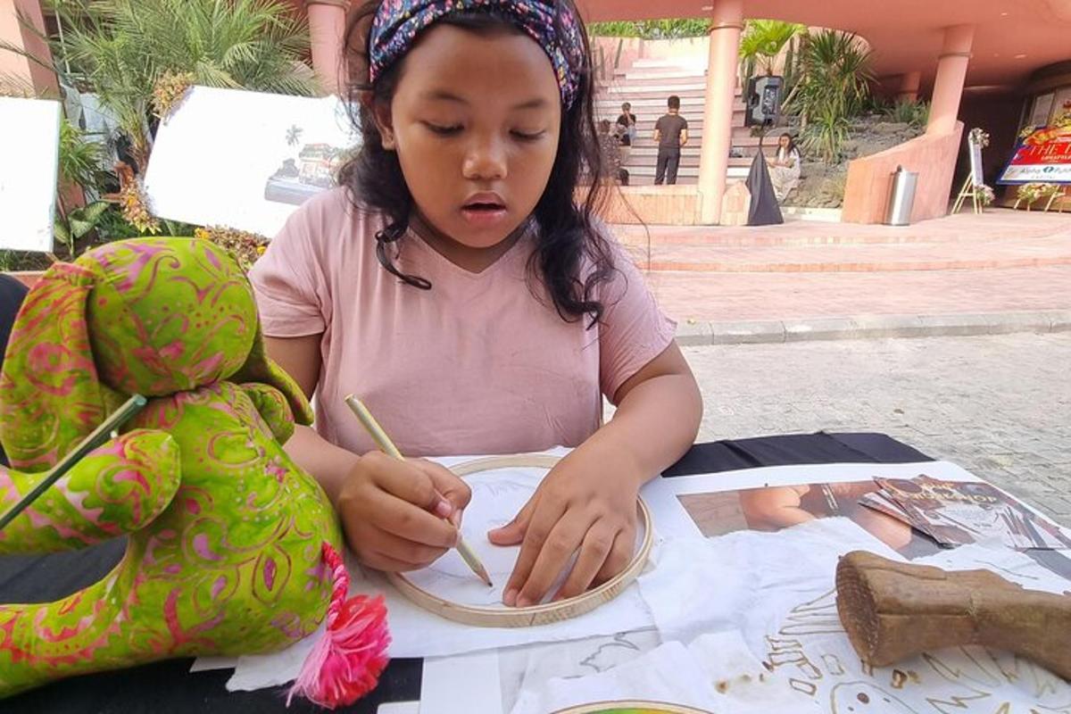 seorang gadis kecil duduk di meja dengan lukisan